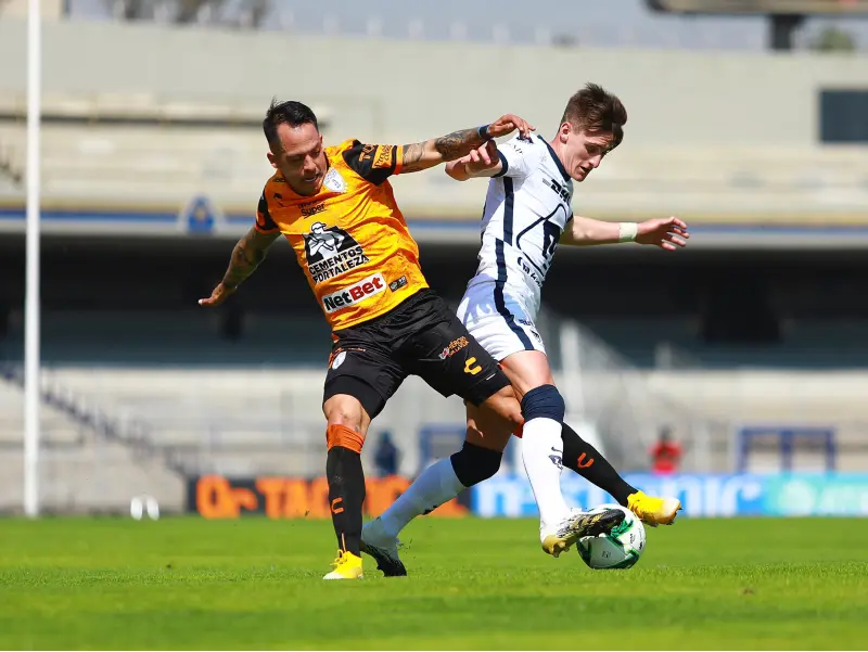 Facundo Waller compite con un jugador de Pachuca en el partido de cuartos de final del Guard1anes 2020 - Twitter @PumasMX