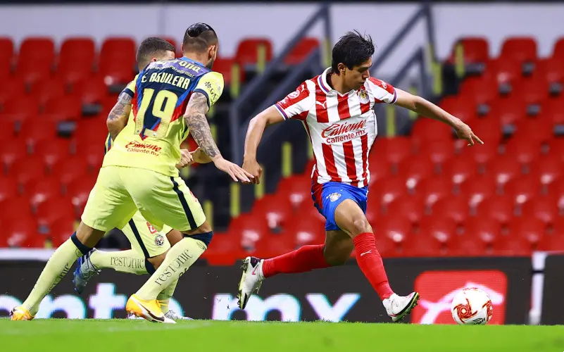 JJ Macías controla una pelota ante la mirada de Emanuel Aguilera