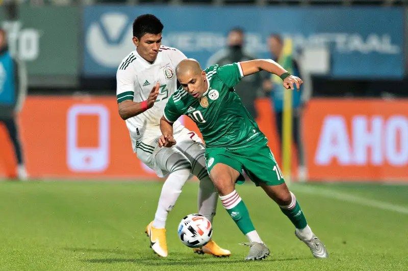 Jesús Gallardo disputa un balón en el México vs Argelia - Twitter @miseleccionmx