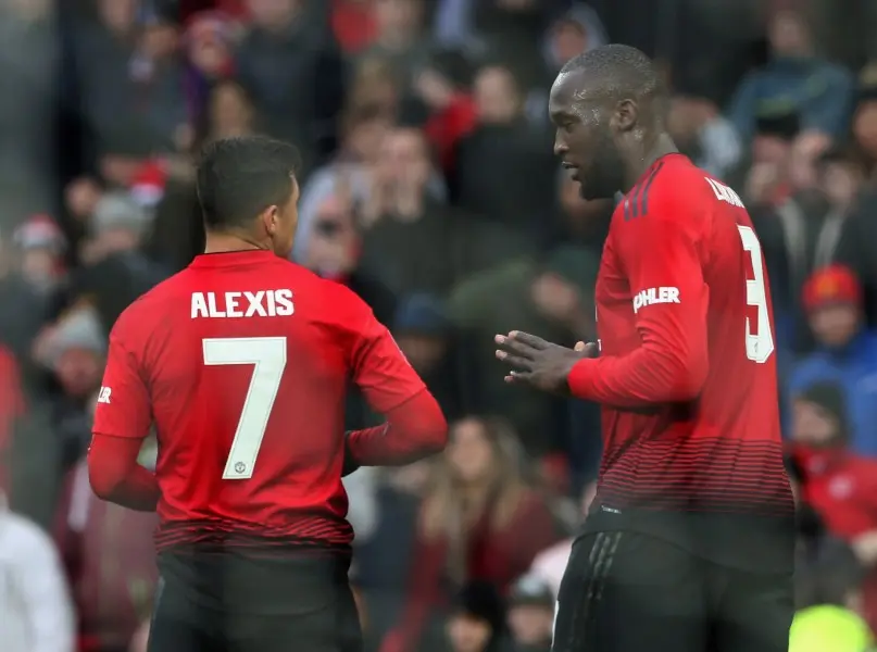 Alexis Sánchez platica con Romelu Lukaku en un partido del Manchester United - Twitter @ManUtd