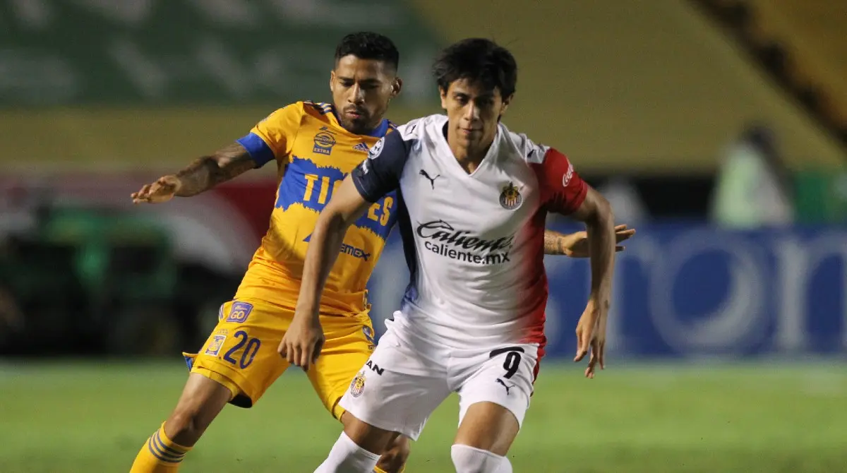 JJ Macías y Javier Aquino disputan una pelota en el Chivas vs Tigres - Twitter @Chivas