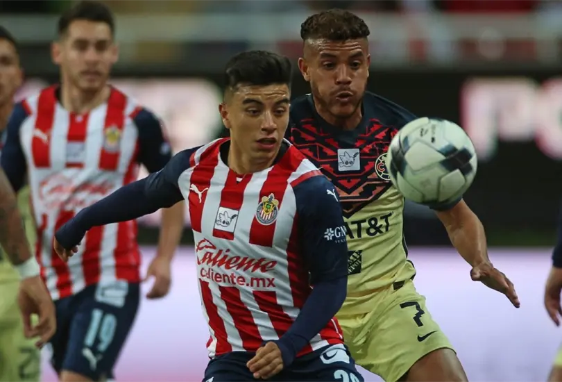 Fernando Beltr&aacute;n y Jonathan dos Santos disputan un bal&oacute;n en el Chivas vs Am&eacute;rica del Clausura 2022